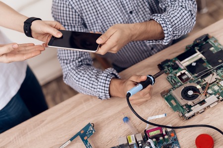 The man works as a radio technician. A man is repairing a printed circuit board.の写真素材