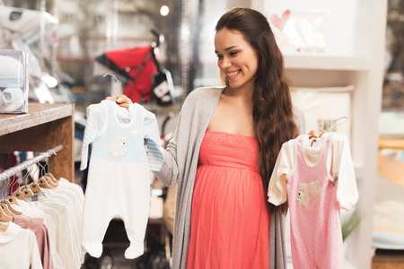 A pregnant woman chooses baby goods in the store.の写真素材