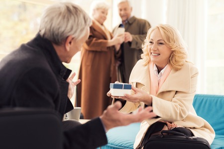 Elderly couple in the airport lounge. They are in the waiting room with suitcases.の写真素材