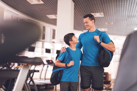 Dad and son in the same clothes in gym. Father and son lead a healthy lifestyle.の写真素材