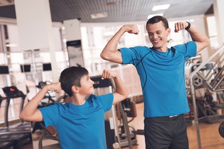 Dad and son in the same clothes in gym. Father and son lead a healthy lifestyle.の写真素材