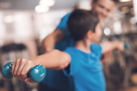 Dad and son in the same clothes in gym. Father and son lead a healthy lifestyle.の写真素材