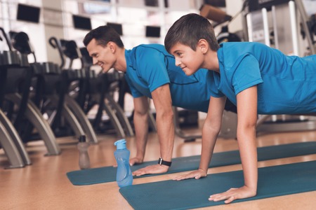 Dad and son in the same clothes in gym. Father and son lead a healthy lifestyle.の写真素材
