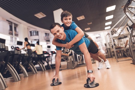 Dad and son in the same clothes in gym. Father and son lead a healthy lifestyle.の写真素材
