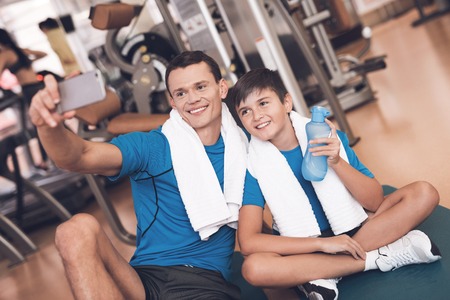 Dad and son in the same clothes in gym. Father and son lead a healthy lifestyle.の写真素材