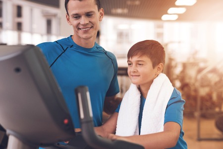 Dad and son in the same clothes in gym. Father and son lead a healthy lifestyle.の写真素材