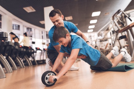 Dad and son in the same clothes in gym. Father and son lead a healthy lifestyle.の写真素材