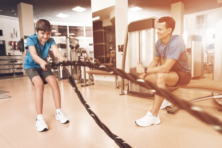 Dad and son in the same clothes in gym. Father and son lead a healthy lifestyle.の写真素材