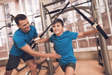 Dad and son in the same clothes in gym. Father and son lead a healthy lifestyle.の写真素材