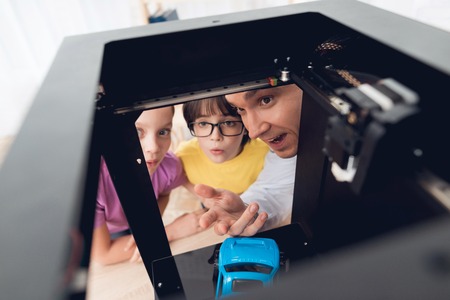 Children print different items on a 3d printer with a teacher.の写真素材