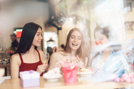 Three girls are sitting together in a cafe.の写真素材