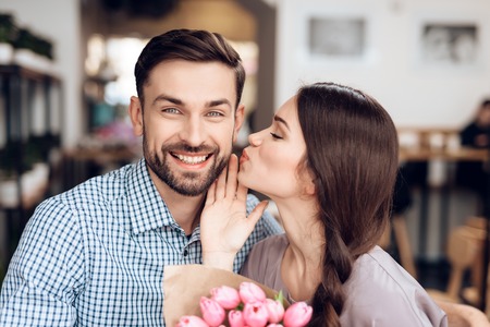 A guy and a girl celebrate a holiday on March 8 in a cafe.の写真素材