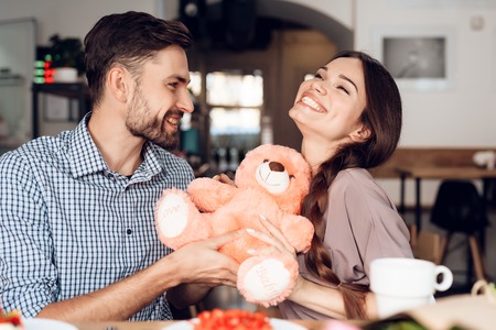 A guy and a girl celebrate a holiday on March 8 in a cafe.の写真素材