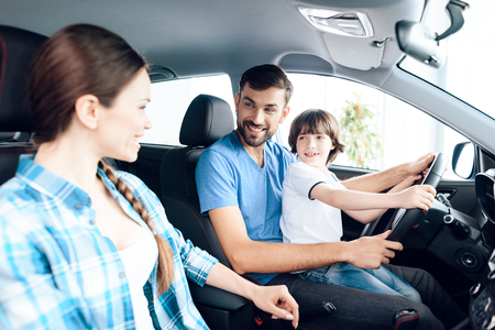 A man with a small son is sitting at the wheel of the car.の写真素材