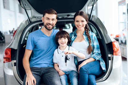 A young family came to the car showroom to choose a new car.の写真素材