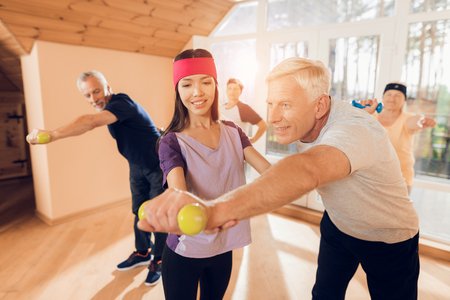 A group of elderly women and men doing therapeutic gymnastics in a nursing home.の写真素材