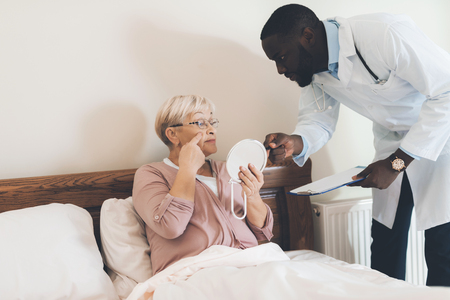 The doctor examines an elderly patient in a nursing home.の写真素材