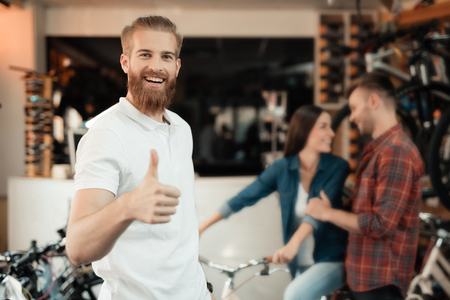 A young man with a beard posing in a bicycle shop.の写真素材