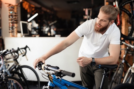The seller in the bicycle shop holds the bicycle handlebars.の写真素材