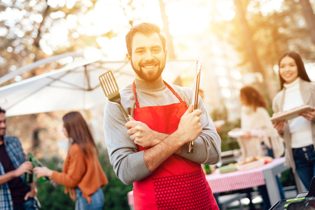 A man is posing on the camera while cooking food on the grill.の写真素材