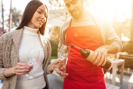 A man and a woman are drinking wine during a picnic with friends.の写真素材