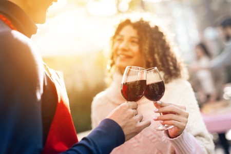 A man and a woman are drinking wine during a picnic with friends.の写真素材