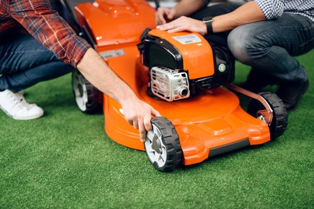 A man starts a lawn mower motor.
