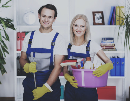 Young smiling couple are holding cleaning tools.の写真素材