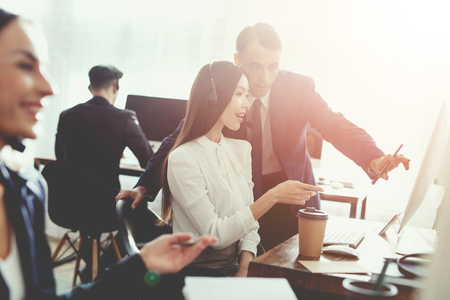 A man with a woman talking to each other in the office. They are both operators of the call center.の写真素材
