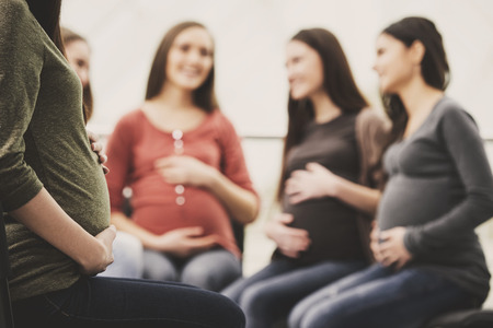 Happy pregnant women are talking together at antenatal class at the hospital.の写真素材