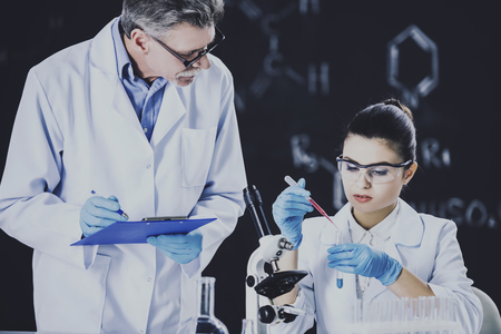 Senior chemistry professor and his assistant working  in  laboratory.の写真素材