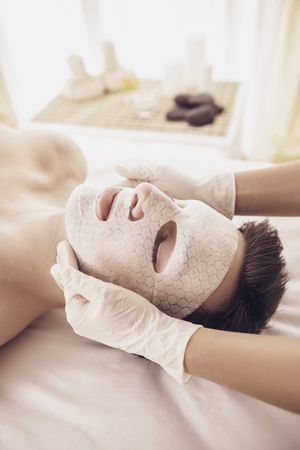 Spa therapy for young asian woman receiving facial mask at beauty salon.の写真素材