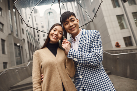 Couple in love under umbrella in background of mall. Romantic concept.の写真素材