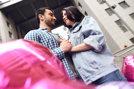 Couple in love near balloons. Guy in plaid shirt hugs girl.の写真素材