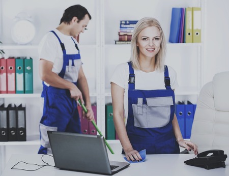 Two janitors with cleaning equipment in office. People cleaned at workplace.の写真素材