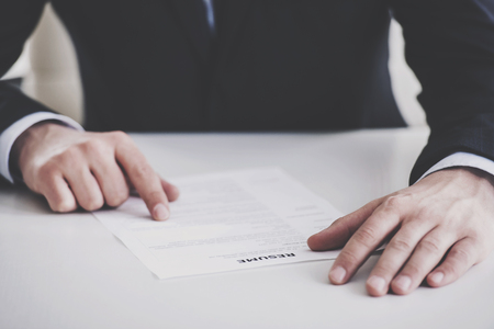 Close up. Young Businessman Taking Resume in Office. Professional HR Manager Sitting in Office and Takes Interview From Employee. Employment and Job Interview Concept. Work Achievement Concept.の写真素材