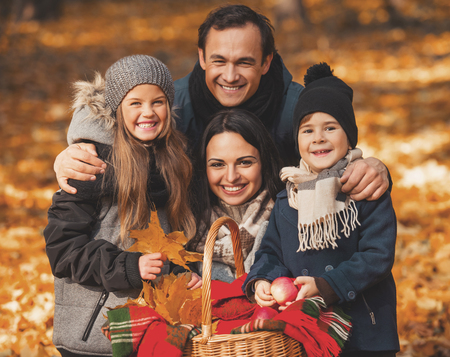 Young Family of Four Have Fun in Autumn Park. Happy Time Spending Outdoor Concept. Young Family...