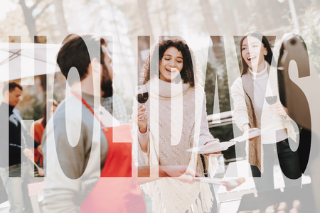 Caucasian Man Talks With Friends On Barbeque. Smiling Friends Are Drinking Wine. Resting Together. Smoked Food. Sweater Weather. Outside Relaxing Activity Concept. Holiday Company Meeting.の写真素材