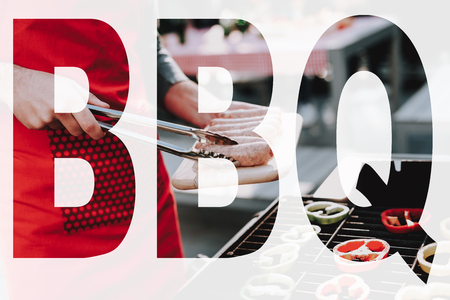 Beautiful Caucasian Man Is Grilling Barbecue. Phone Talking. Smoked Food. Nature Activity. Outside Relaxing Concept. Smiling Friends Are Having Fun. Resting Together. Couple Backstage.の写真素材