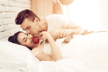 Happy Couple Are Lying In Bed At Valentine's Day. Love Each Other. Sweetheart's Holiday Concept. Feelings Showing. Celebrating Date. Young And Handsome. Eyes Closed Couple. Happy Together.の写真素材