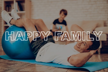 Father And Son Are Exercising With Fitness Ball. Healthy Lifestyle. Active Holiday. Exercises Clothes. Getting Better. Working Out At Home. Sports Equipment. Repeating Practice. Body Shaping.の写真素材