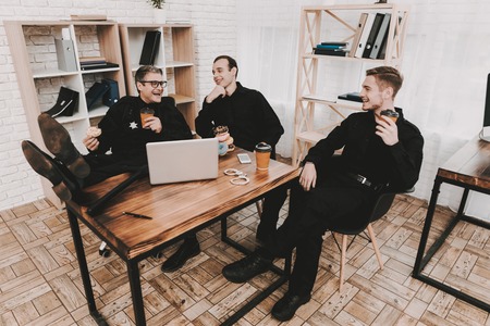 Smiling Officers In Department Office. Relaxing Concept. Coffee Break. Cop's Donuts. Working Together. Citizen's Protection. Public Order. Phone Talking. Handscuffs On Table. Detective Uniform.の写真素材
