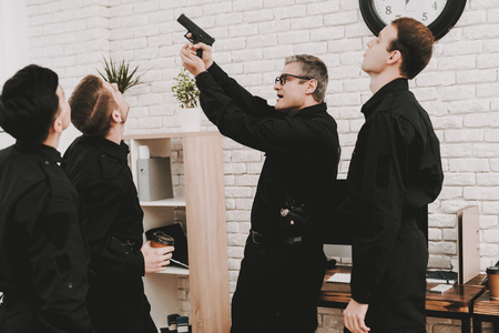 Smiling Officers In Department Office. Relaxing Concept. Coffee Break. Tasty Donuts. Working With A Gun. Citizen's Protection. Public Order. Phone Talking. Handscuffs On Table. Detective Uniform.