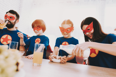 Young Family In Superhero Suits. Dinner Concept. Masks And Raincoats. Bright Room. Resting Together. Juice And Cereals. Get Ready. Healthy Lifestyle. Kids With A Parents. Active Leisure.の写真素材