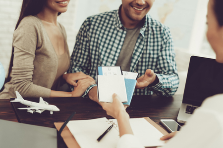 Manager in Travel Agency Giving Tickets To Couple. Consultant in Travel Office. Airplane Tickets. Family Journey Concept. Weekend Holidays and Vacation. Tourism Concept. Travelling Couple.の写真素材