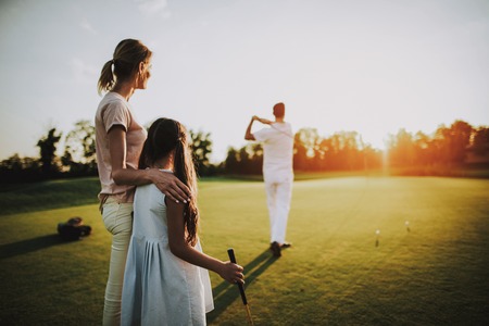 Happy Young Family Relax on Golf Field in Summer. Relaxing in Golf Club. Sports in Summer. Outdoor Fun in Summer. Family Fun Concept. Healthy Lifestyle Concept. Little Girl. Green Grass.の写真素材