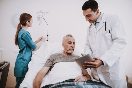 Nurse Doctor and Patiend in Clinic. Doctor and Patien. Patient and Nurse. Patiend in White Room with Doctor and Nurse. White Room and Old Man. Hospital and Old Man. Therapy for Old Man in Hospital.の写真素材