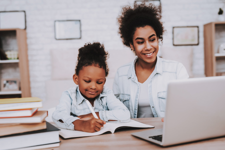 Young Girl and Lessons. Study for Young Girl. People and relaxation Time. Smile and Good Time Together. Mother and Young Girl Together Time. Studio and Smile Young Girl. Work and Young Day Together.の写真素材