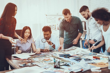 Generate Idea. Colors for Design. Different Races. Project. Landscape. Designers. Group. Teamwork. Designers. Cooperation. Brainstorming. Work. Table. Large Bright Office. Discuss. Samples. Schemes.の写真素材