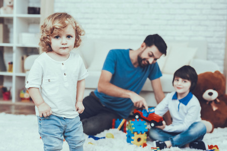 Baby with Bright Hair. Family. Holidays. Leisure Time. Smiling Kids. Father. Father Two Boys. Man. Smile. Home Time. Two Boys. Plays Games. Toys. Teddy Bear. Cars. Spends Time Together.の写真素材